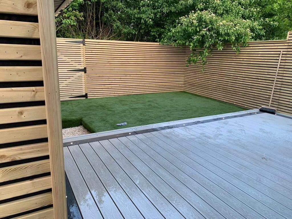 This low-maintenance garden is made up from artificial turf, composite decking, floor and panel lighting, and pressure-treated timber.